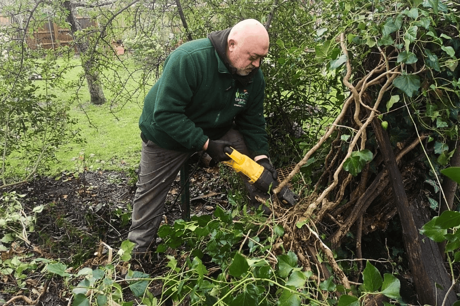 Gardener from Urban Gardeners South East London wotking in an overgrown garden
