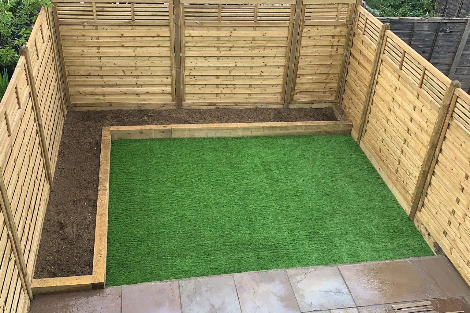 garden-landscaping-urban-gardeners-south-east-london Backyard in South East London with green artificial grass and wooden fencing