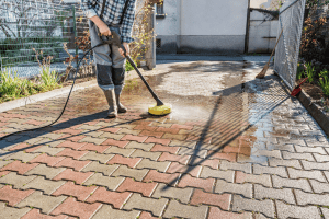 Half-cleaned patio in a South East London garden showing the difference between jet washed and dirty paving
